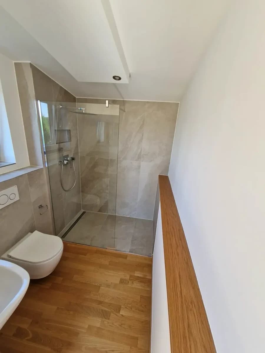 Komplettbad mit ebenerdiger Regendusche, Hänge-WC und beheiztem Fliesenboden - Badsanierung in Hamburg